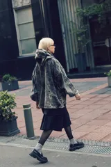 Canguro oversize de denim gris lavado, con capucha, cuello alto con cierre metálico, puños elásticos y bolsillo frontal tipo canguro.