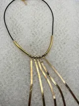 Collar dorado con colgantes de cadena fina y cordón negro.