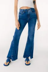 Pantalón de jean azul de corte acampanado con aberturas en el ruedo.