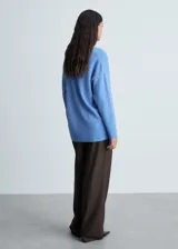 Sweater color beige de tejido de punto con cuello en V y corte oversize.