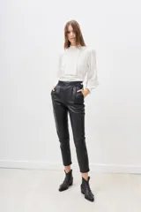 Pantalón negro de cuero ovino con cintura alta y corte cigarette.