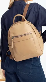 Mochila pequeña de símil cuero color negro, con bolsillo frontal con cierre, asa de mano y correas regulables.