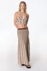 Falda midi tejida a rayas verticales en tonos celeste y azul, con cintura elástica y abertura lateral.