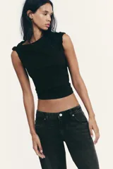 Pantalón de jean celeste claro, de tiro bajo, corte wide leg y largo hasta el tobillo. Tiene cinco bolsillos, cierre frontal con cremallera y botón metálico.