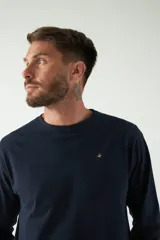 Remera gris de manga larga con cuello redondo y logo bordado en el pecho.