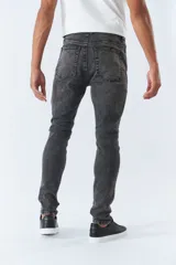 Jean skinny de tiro medio, en color negro desgastado, con logo bordado y pasa cinto.