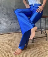 Pantalón de cuero azul con corte jean, tiro medio-alto y abertura lateral en el ruedo.