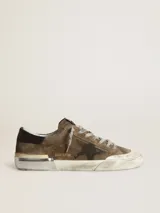 Zapatillas deportivas Golden Goose modelo Super-Star, color marrón verdoso desgastado, con estrella lateral negra y detalles en cuero negro en el talón. Presentan un acabado intencionalmente envejecido en la suela y cordones grises. En el lateral se lee el texto 'GGDB/SSTAR'.