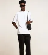 Pantalón baggy negro de algodón y poliéster, con cintura elástica ajustable con cordón, bolsillos laterales tipo cargo y bolsillo trasero.