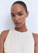 Vestido midi color crudo, de corte recto y sin mangas.