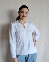 Camisa blanca de mangas largas con detalle de frunce en los hombros y cuello en V.