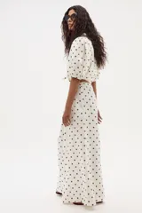 Pantalón de lino color crudo con lunares marrones, de corte ancho y tiro medio-alto, con elástico en la parte trasera de la cintura.