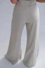Pantalón de lino color beige, de corte palazzo y tiro alto.