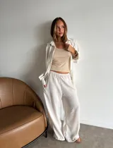 Pantalón de viscosa color beige claro, de corte amplio y pierna ancha, con cintura elástica y bolsillos laterales.