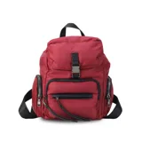Mochila negra de nylon con tapa y broche metálico. Tiene apertura superior con broche, bolsillos internos, bolsillo con cierre metálico al frente y laterales. Tiene asas rígidas de mano y correas regulables para colgar en la espalda.