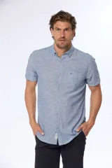Camisa celeste de lino y algodón, de manga corta, con cuello abotonado y bolsillo en el pecho.
