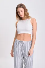 Musculosa corta blanca de tejido de punto acanalado, corte ajustado y cuello redondo.