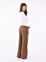 Pantalón negro de corte ancho y tiro alto, con cordón ajustable en la cintura.