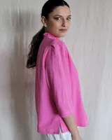 Camisa blanca de mangas 3/4 con cuello mao y botones frontales.