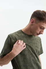 Remera blanca con estampado abstracto en tonos grises, de manga corta, corte regular y cuello redondo.