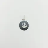 Dije redondo de plata 925 con el símbolo de la balanza de la justicia.