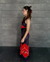 Vestido largo negro con estampado de flores rojas, de tirantes finos y corte al cuerpo.