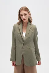 Blazer blanco de lino con hombreras, corte entallado, cuello solapa y cierre con botón.