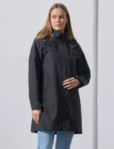 Gabardina impermeable negra, marca Weatherproof, con cierre central oculto y botones a presión. Tiene bolsillos delanteros con cierre, capucha no desmontable y forro interno de abrigo desmontable.