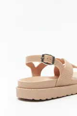 Sandalia color verde militar con tiras anchas cruzadas y hebilla metálica ajustable en el tobillo.