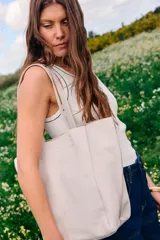 Cartera tipo shopper de cuero color crudo, sin forro y con terminaciones al corte. Presenta gran capacidad y un bolsillo interior con cierre.