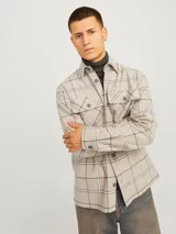 Sobrecamisa beige a cuadros con dos bolsillos frontales con botón, de manga larga y corte recto.