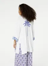 Kimono blanco con estampado de palmera azul en la espalda y detalles geométricos azules en los puños y el ruedo.