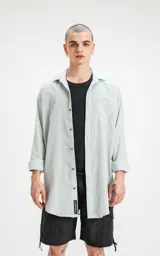 Camisa manga larga verde agua, de calce oversize con bolsillo ojal en delantero y cartera escondida.