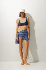 Top de bikini marrón con contorno rojo y breteles finos.