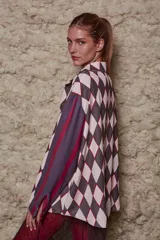 Camisa holgada con estampado de rombos en tonos rosa y marrón, con cuello solapa y abotonada. Tiene mangas largas con rayas verticales en tonos borgoña y violeta.