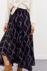 Falda larga de viscosa jacquard con lurex dorado, estampado geométrico, tajo central, ruedo irregular y cintura elastizada.