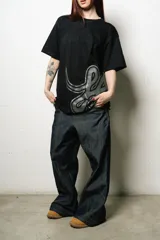 Remera negra de corte regular fit, confeccionada en jersey de algodón. Presenta un estampado plastisol de alta calidad en el frente.