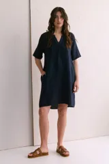 Vestido corto color arena, de lino, con escote en V y mangas cortas.