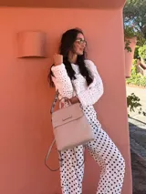 Mochila color verde oliva, tipo cartera, con tapa y doble cierre. Tiene dos compartimentos y división interna, además de un bolsillo trasero con cierre.