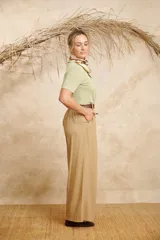 Pantalón ancho color beige de lino con cinto y pretina con elástico en la parte de atrás.