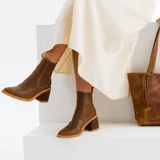 Botas cortas de cuero color marrón, con taco de madera forrado en cuero, elástico lateral y punta fina.