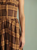 Vestido midi marrón a cuadros con breteles anchos, espalda semi-baja y cordones ajustables en la parte superior.