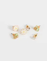 Set de tres pares de aros con pasantes y cierre de tope a presión: un par con forma de margarita blanca con centro amarillo, un par con strass engarzado y un par con forma de uvas con strass verde.