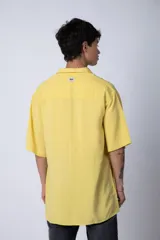 Camisa celeste de manga corta con cuello clásico y calce oversize.