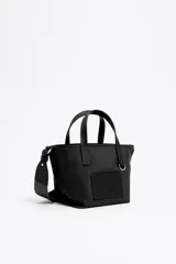 Bolso shopper mini Bimba y Lola de nailon negro con estructura blanda, doble asa de mano y asa de tejido, piezas de piel, logo grabado, acabados metálicos en plateado y cierre de cremallera.