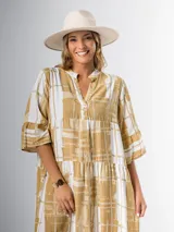 Vestido midi de corte amplio con estampado abstracto en tonos azules, blancos y beige. Tiene cuello en V, mangas 3/4 con volados y corte escalonado en la falda.