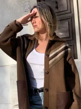 Saco marrón de lana con cuello camisero, cierre con botones y detalle de crochet en los hombros.