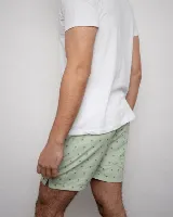 Short de baño celeste con estampado de palmeras en negro, cintura elástica con cordón ajustable y bolsillos laterales.