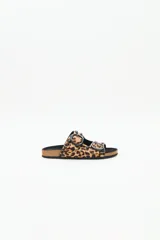 Sandalia tipo birkenstock de pelo con estampado animal print (leopardo), con dos tiras ajustables con hebillas negras y tachas metálicas negras. La plantilla es de corcho y la suela de goma eva.