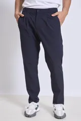 Pantalón de vestir azul marino, de corte recto, con bolsillos laterales y traseros. Se ajusta a la cintura con cinturón de cuero marrón.